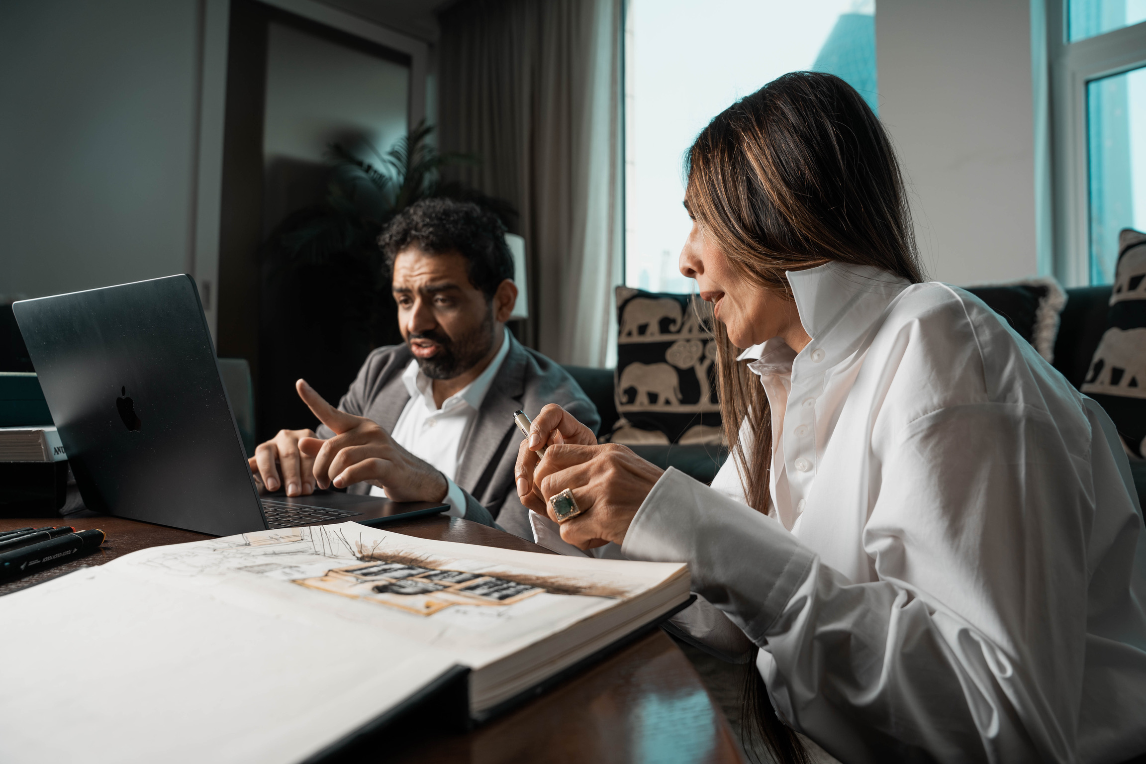 Bushra Khokhar and Tariq Ismail working through a design over the studio sketchbook and laptop